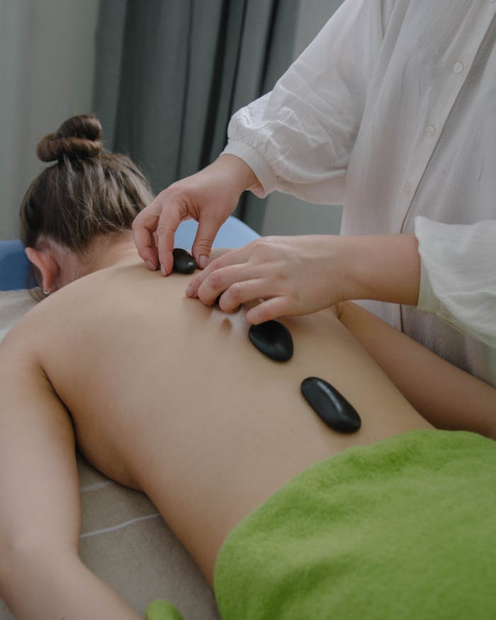 A serene hot stone massage session indoors promoting relaxation and wellness.